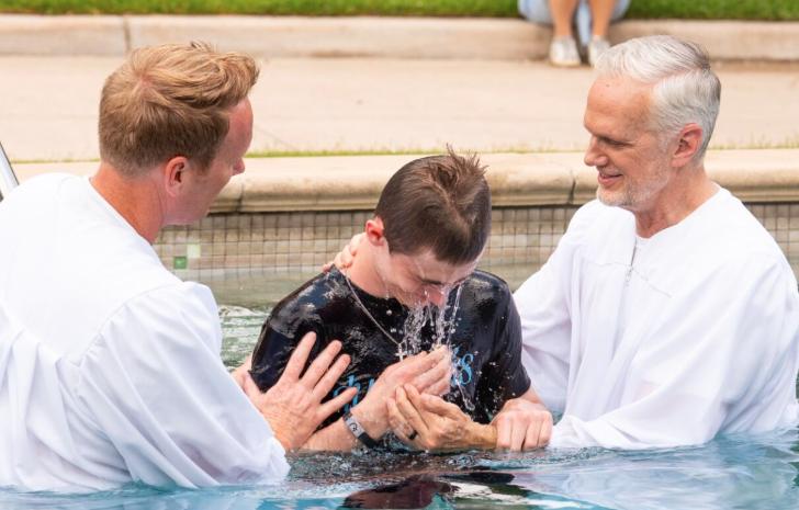 Pastor Ben Young on stage reading from a Bible