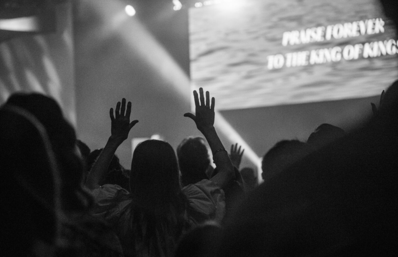 Man stading towards stage with arms raised